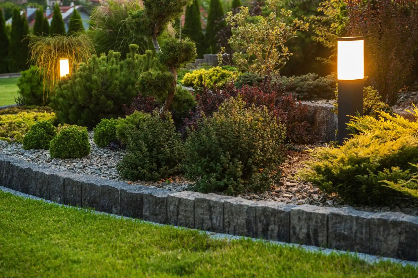 Retaining wall with integrated landscape lighting at dusk